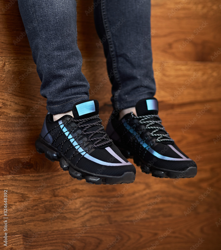 black and blue shoes hanging down on the wooden background black and blue shoes hanging down on the wooden background