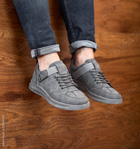 casual gray grey sport shoes hanging down on the wooden background