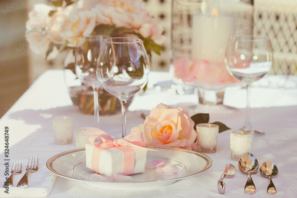 Small gift with pink ribbon on table Small gift with pink ribbon on table