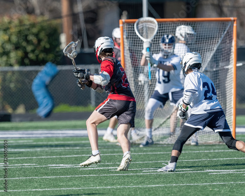 Young athletes making amazing plays while playing in a Lacrosse game photo