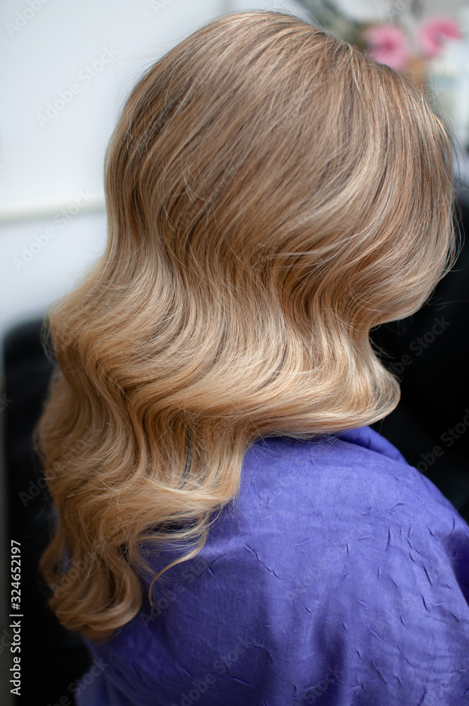 Naklejka premium Blond woman with hairstyle of long wavy hair