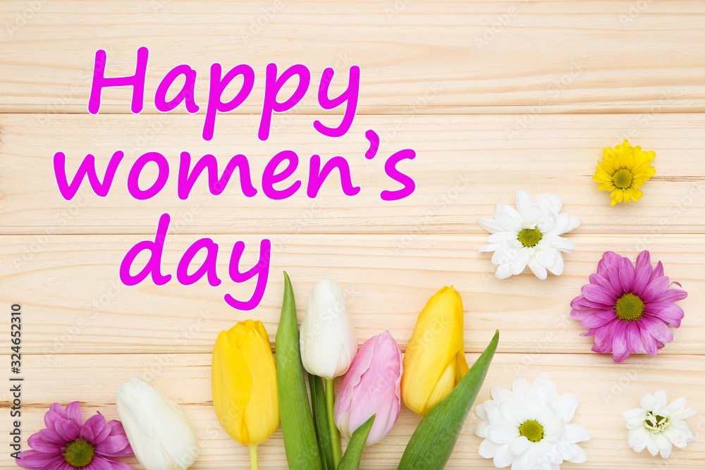Fototapeta premium Text Happy Womens Day with tulip and chrysanthemum flowers on brown wooden table