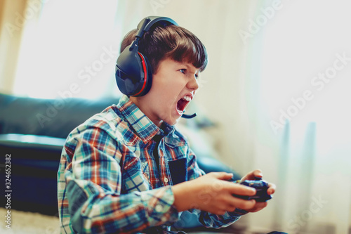 Stampa su tela Crazy dependent kid shouting while playing mass multiplayer video game online