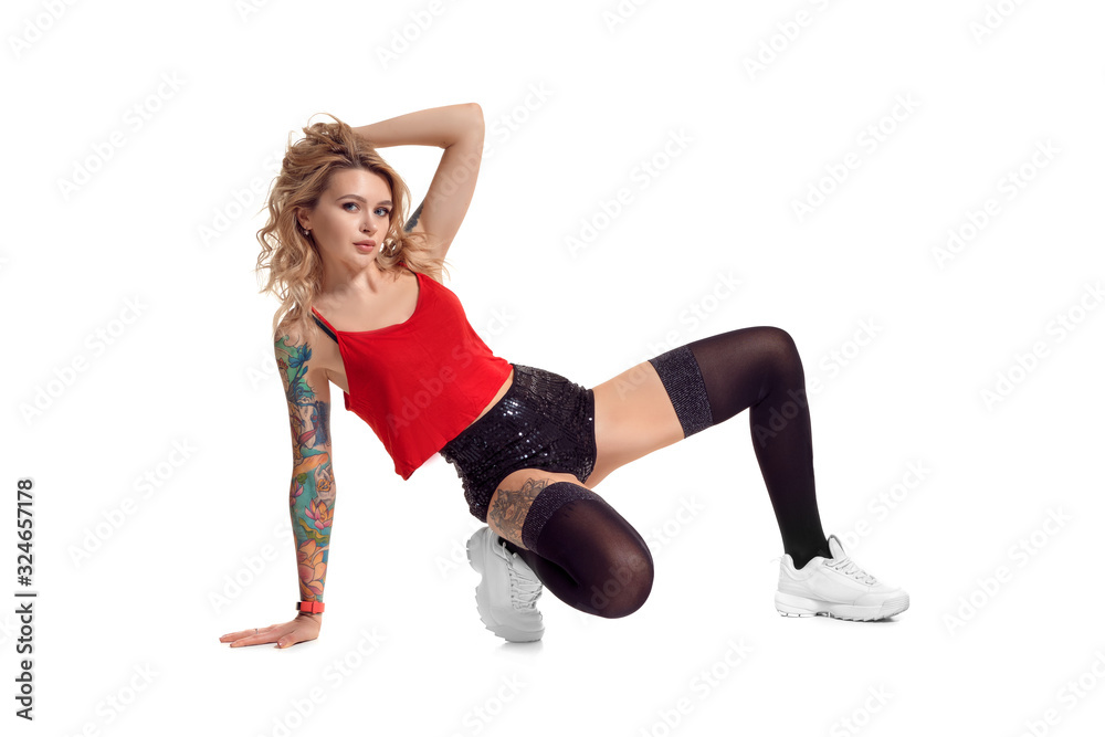 Sexy blond twerk woman with tattoed body and long curly hair is posing in studio. Sexy blond twerk woman with tattoed body and long curly hair is posing in studio.
