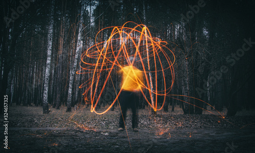 Sparks from steel wool in the evening forest photo