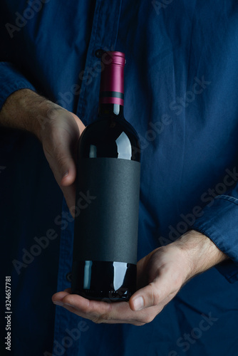 sommelier, male hands holding a bottle of wine photo