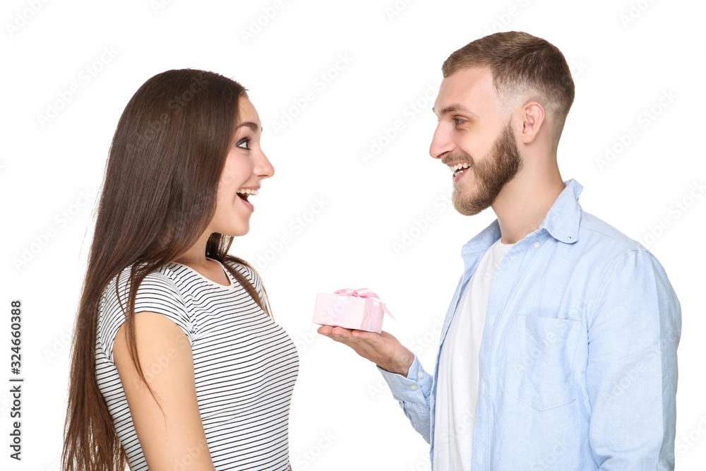 Young man giving gift box to his girlfriend on white background Young man giving gift box to his girlfriend on white background