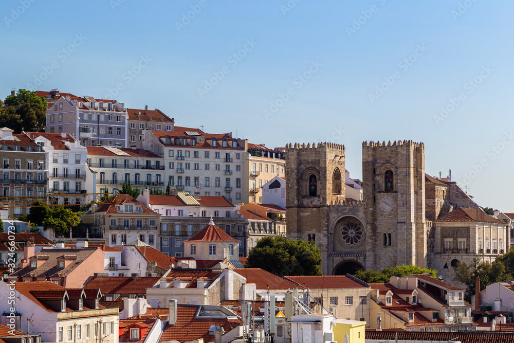 View of the Se Cathedral (Lisbon Cathedral) and old buildings at the historical Alfama district in downtown Lisbon, Portugal, on a sunny day. 