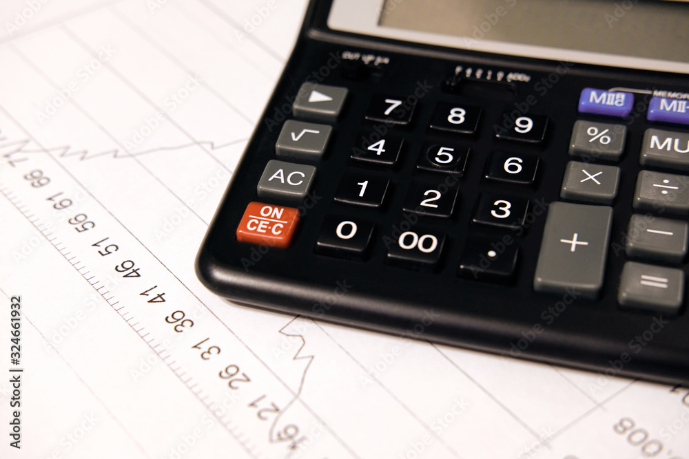 Black calculator to count numbers on a sheet with a graph Black calculator to count numbers on a sheet with a graph