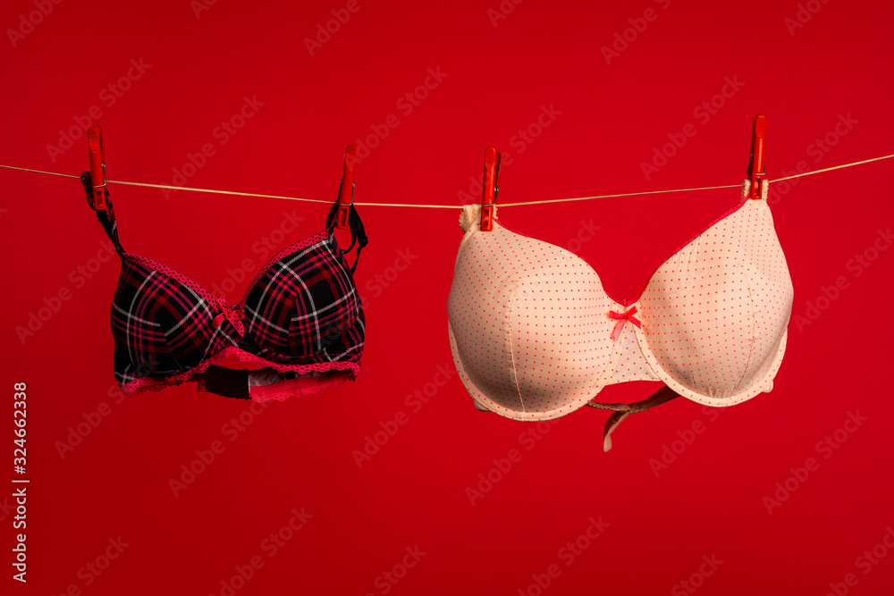 Breast size. Brassiere. Women's lingerie hanging at rope . Bra and  bustiers. Small little or big breast size. Stock Photo