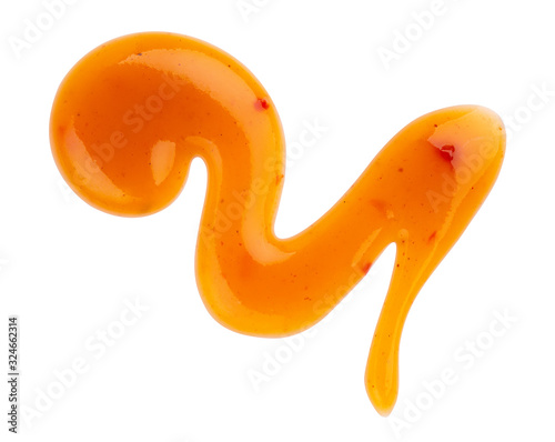 Dripping orange sauce isolated on white background with clipping path. Abstract pattern made of chili sauce. Flat lay, top view, close up.