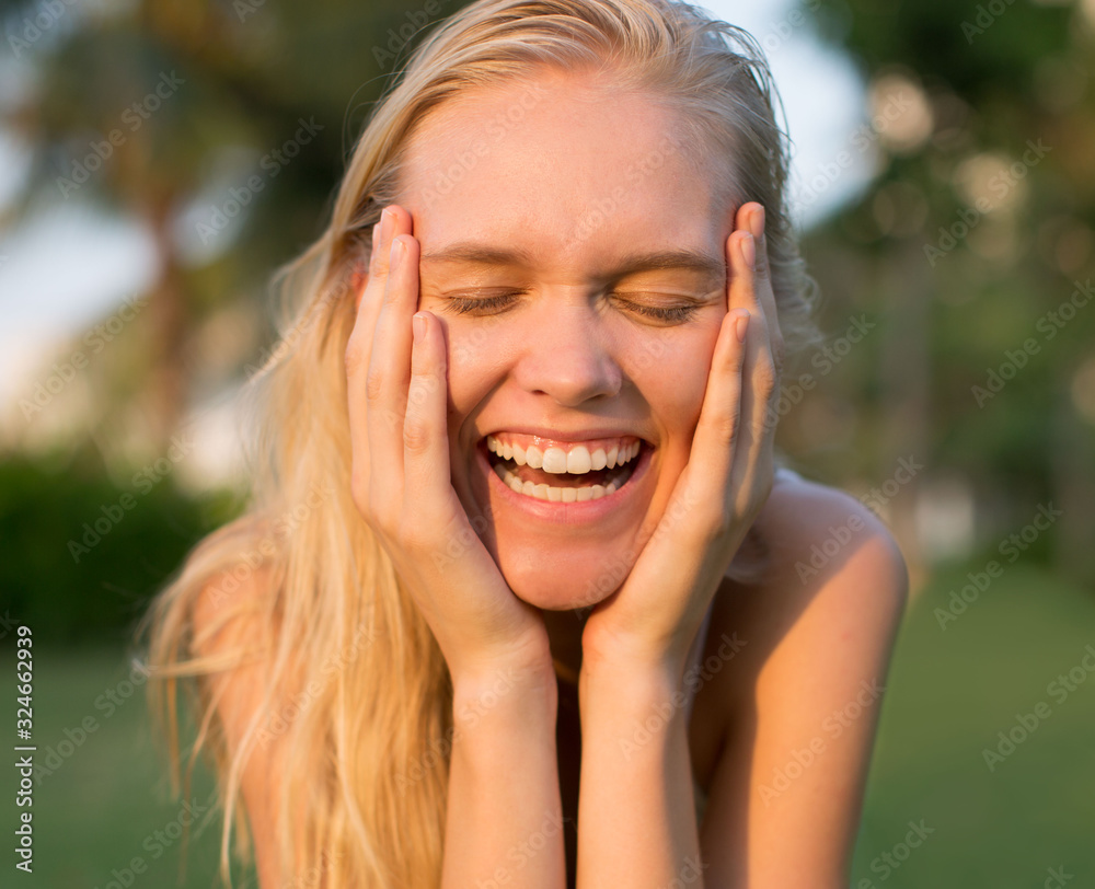 Fototapeta premium beautiful blonde woman laughing with eyes closed. big white teeth smile.