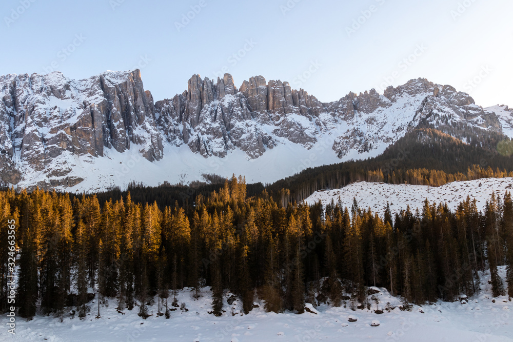 The famous mountains latemar in south tyrol, italy, with the frozen lake karersee in the front The famous mountains latemar in south tyrol, italy, with the frozen lake karersee in the front