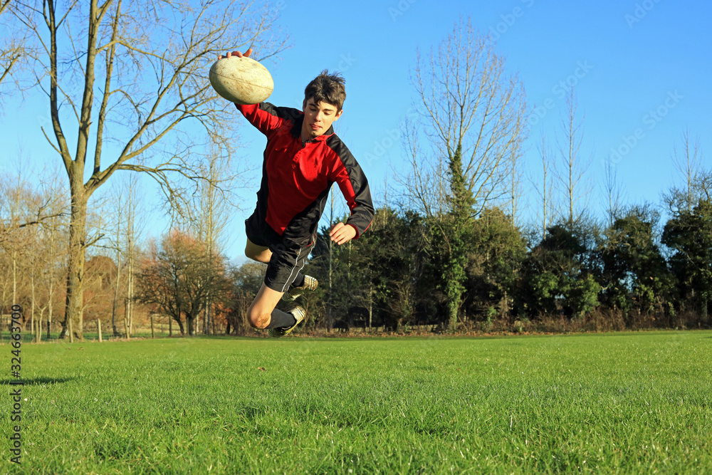 Teenage Rugby Player Jumping High To Score A Try Teenage Rugby Player Jumping High To Score A Try