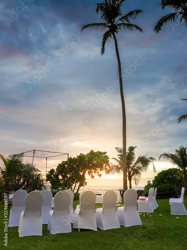 Beautiful romantic wedding ceremony under palm trees on the ocean beach at sunset photo