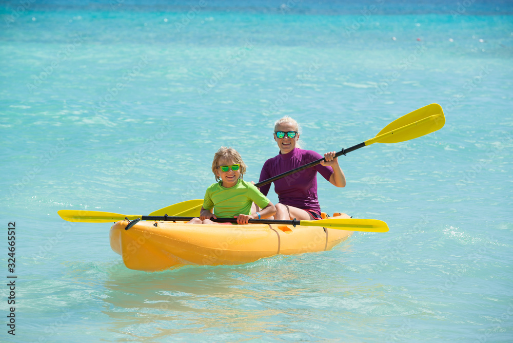 Happy family with kayaks during summer vacations.Mather and son enjoy the time together .