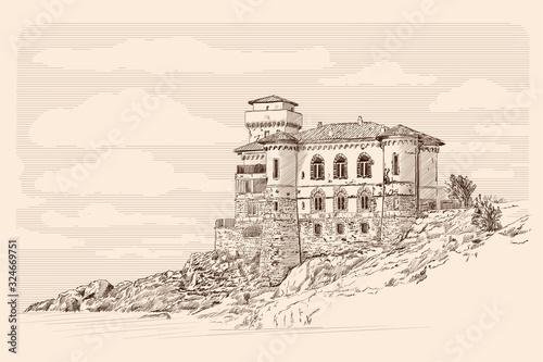 Medieval stone castle with towers on the rocks by the sea.