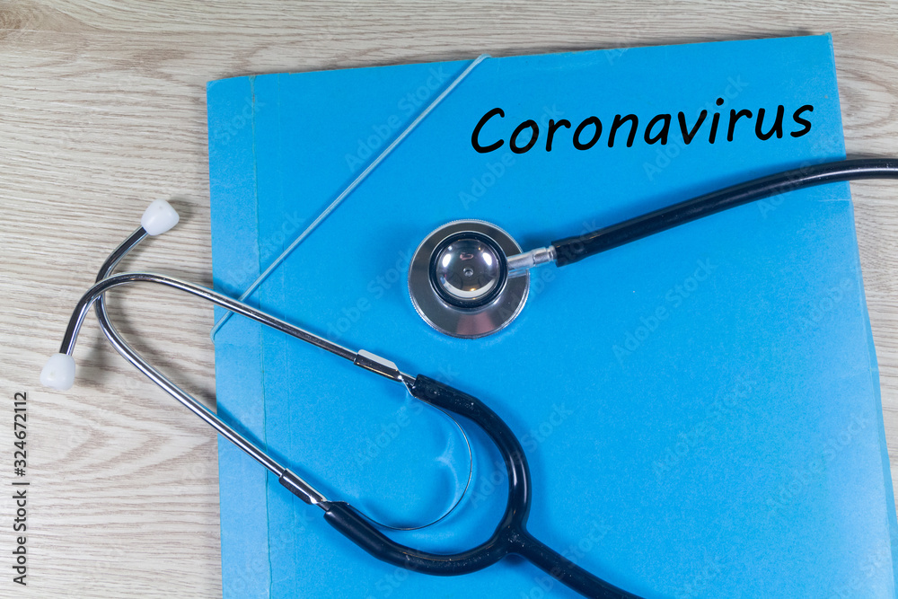 Coronavirus written on a blue file and black stethoscope Coronavirus written on a blue file and black stethoscope