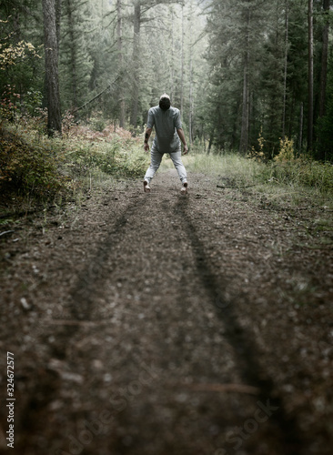 Man being dragged through the forest by an invisible force, conceptual imagery