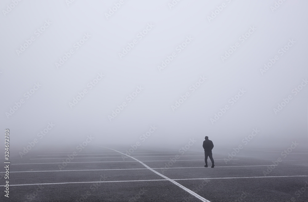 Man walking through very foggy parking lot, Glacier National Park