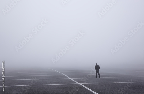 Man walking through very foggy parking lot, Glacier National Park