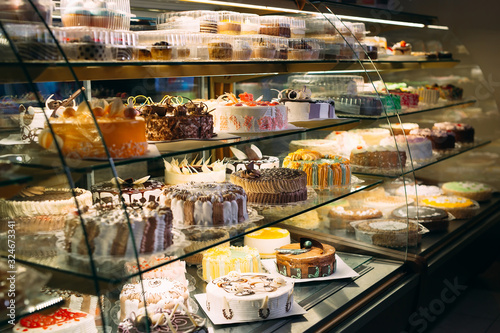 Fényképezés Pastry shop glass display with selection of cream or fruit cake.