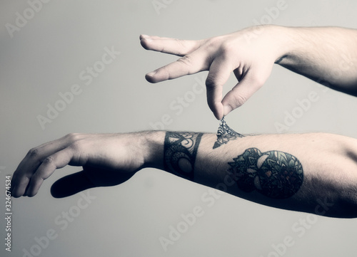 Man peels off his tattoo from his arm, conceptual image