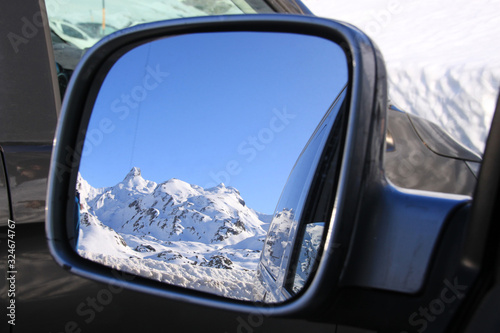 rear mirror with a snowed mountain reflected in it