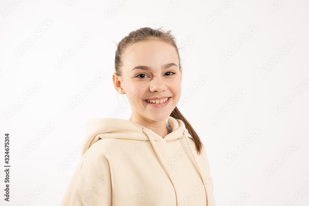 Happy smiling brunette girl in beige hoodie looking at the camera isolated over white background Happy smiling brunette girl in beige hoodie looking at the camera isolated over white background