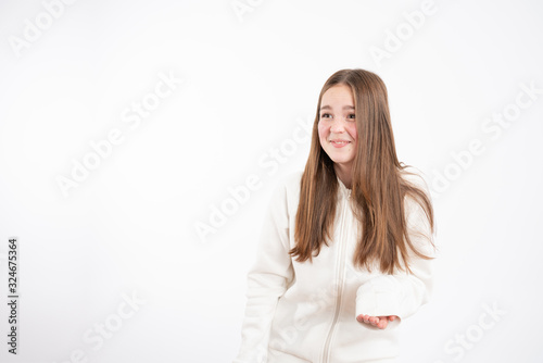 Embarrassed readhead girl in white hoodie looking at left side isolated over white background photo