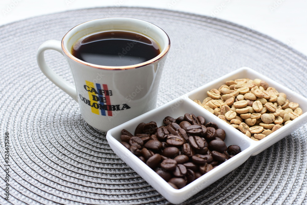 Fototapeta premium Traditional cup of Colombian coffee with coffee beans on wooden background