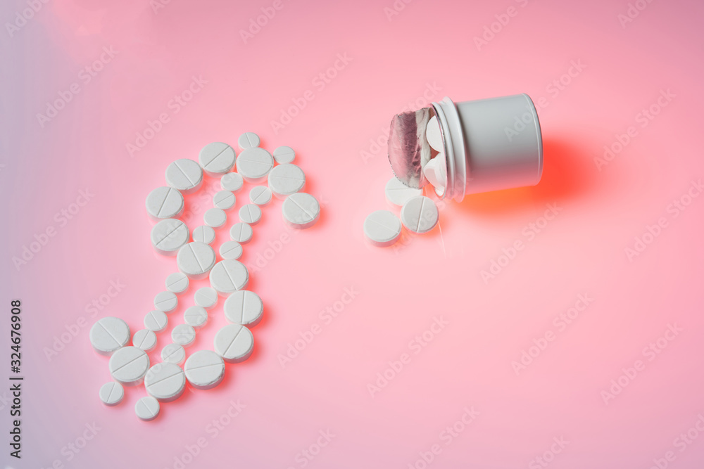 Bottle with medicines lies on a pink background. Pharmacy business, medicine pill concept.Close up and top view. Bottle with medicines lies on a pink background. Pharmacy business, medicine pill concept.Close up and top view.