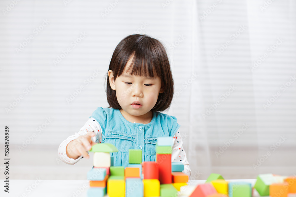 toddler girl playing creative toy blocks at home against white background toddler girl playing creative toy blocks at home against white background