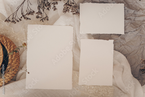 Wedding invitation mockup with dry plants , papers on white textile background. Top view, flat lay. Wedding stationary. Perfect for presentation of your invitation, menu, greeting cards