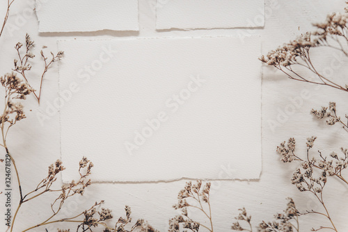 Wedding invitation mockup with dry plants , papers on white textile background. Top view, flat lay. Wedding stationary. Perfect for presentation of your invitation, menu, greeting cards