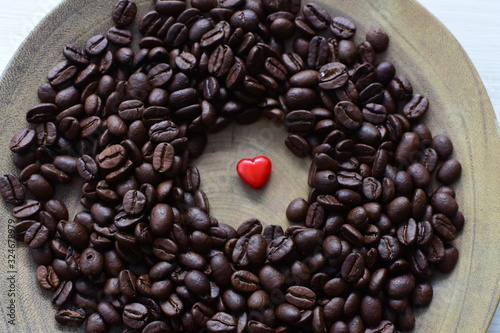  Processed coffee beans and tostao  with red heart on wooden background