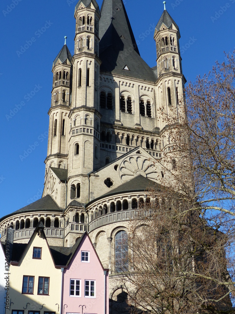 Turm von Gross-Sankt-Martin mit Hausfassaden in Köln / Hochformat