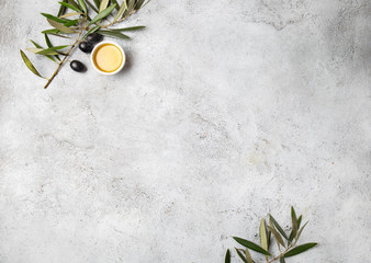 Food background with linen napkin, olive tree branch, olive oil on concrete background