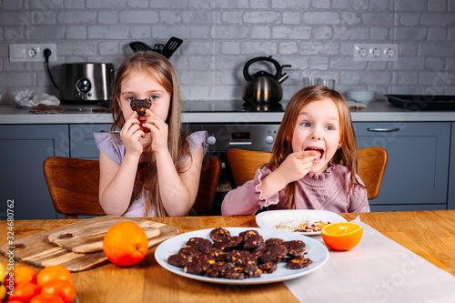 Young girls eating biscuits at home