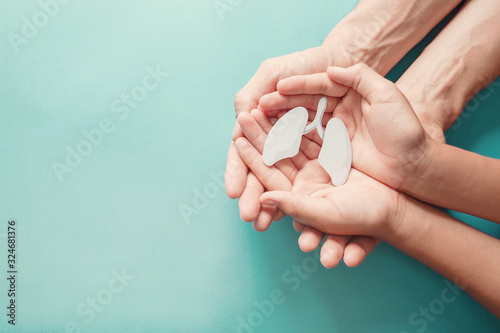 Adult and child hands holding lung, world tuberculosis tb day, world no tobacco day, lung cancer, long covid, COPD,  eco air pollution, organ donation concept photo