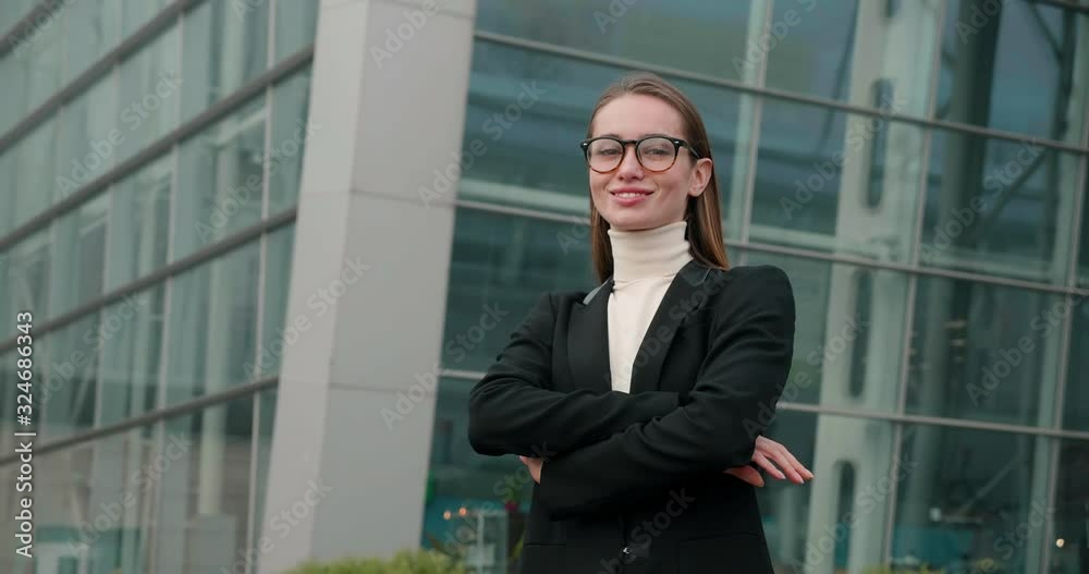 Beautiful woman with Elegant Hairstyle standing in the Town, putting on her Eyeglasses. Wearing stylish Formal Clothes. Having charming Smile, looking Satisfied. Attractive female Office Manager. Beautiful woman with Elegant Hairstyle standing in the Town, putting on her Eyeglasses. Wearing stylish Formal Clothes. Having charming Smile, looking Satisfied. Attractive female Office Manager.