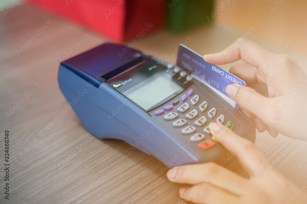 The store staff is swiping a credit card to pay for the product. Concept of payment using a debit card. The store staff is swiping a credit card to pay for the product. Concept of payment using a debit card.
