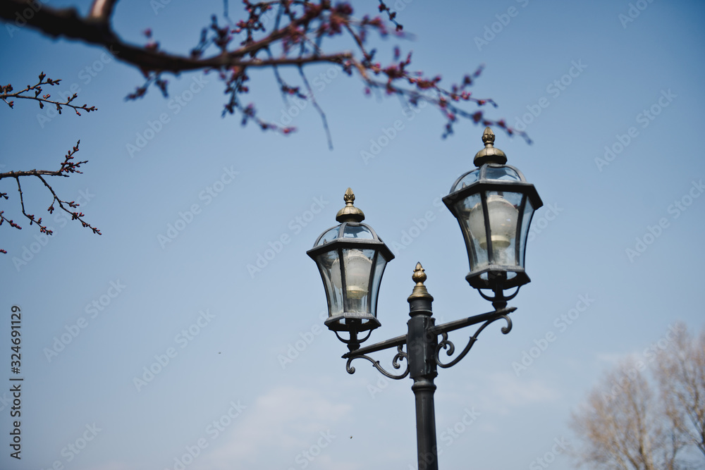 Vintage old electric street light against the blue sky,