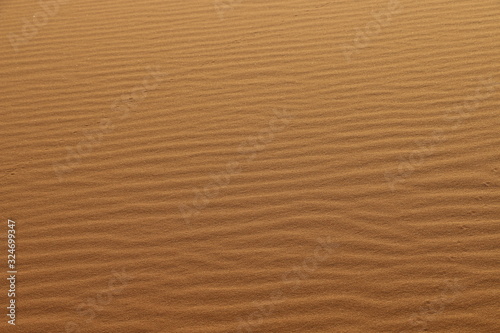 sand texture - background of desert sand dunes. Beautiful structures of sandy dunes. sand with wave from wind in desert - Close up