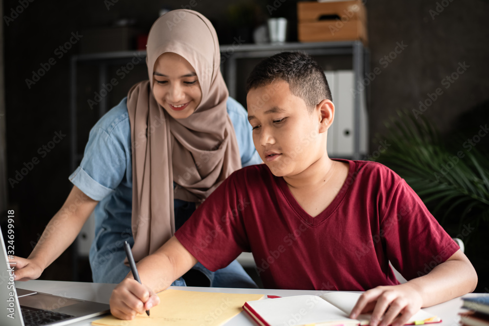 Naklejka premium The teacher teaching two muslim students doing activity together,at school,
