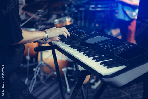 Musician playing on the keyboard synthesizer piano keys. Musician plays a musical instrument on the concert stage