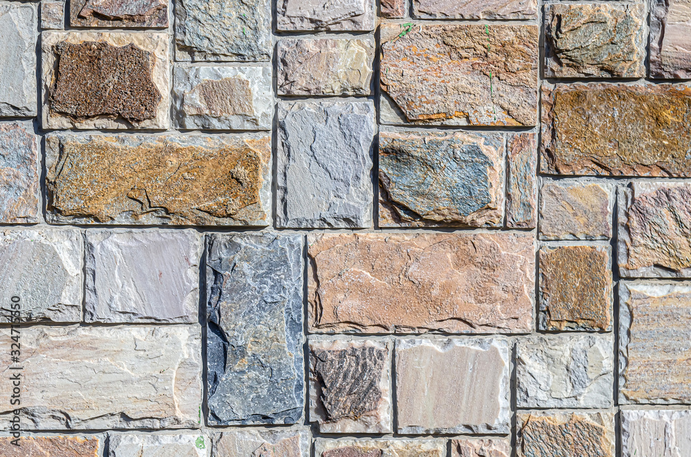 Fototapeta premium Wall of colored artificial stone as a background.