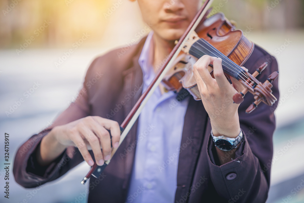 Closeup of musician man is practicing the violin playing with the melodiousness. Selected focus. Closeup of musician man is practicing the violin playing with the melodiousness. Selected focus.