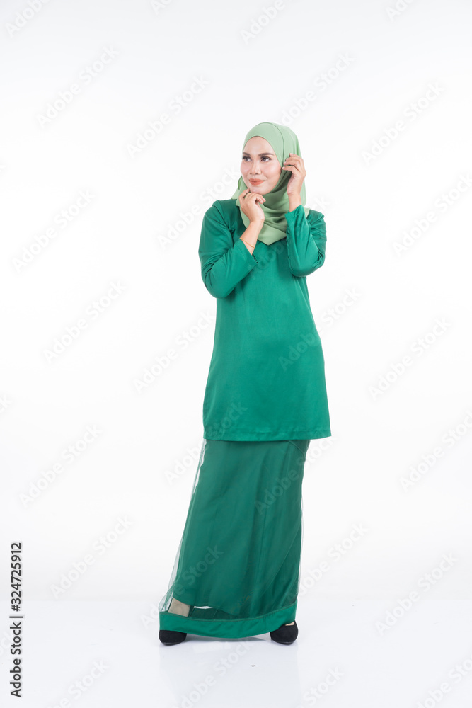 Beautiful female model in modern kurung and hijab, a modern lifestyle apparel for Muslim women isolated on white background. Beauty and hijab fashion concept. Full length portrait Beautiful female model in modern kurung and hijab, a modern lifestyle apparel for Muslim women isolated on white background. Beauty and hijab fashion concept. Full length portrait