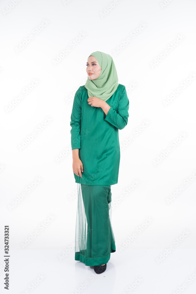 Beautiful female model in modern kurung and hijab, a modern lifestyle apparel for Muslim women isolated on white background. Beauty and hijab fashion concept. Full length portrait Beautiful female model in modern kurung and hijab, a modern lifestyle apparel for Muslim women isolated on white background. Beauty and hijab fashion concept. Full length portrait